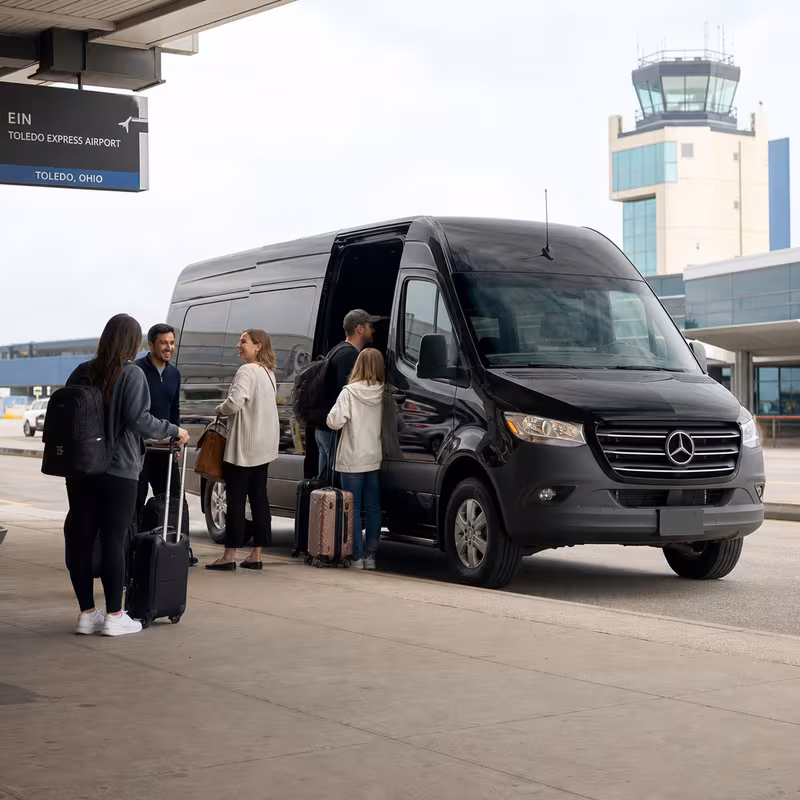 Group boarding a white charter bus for Airport Transportation transportation in Toledo