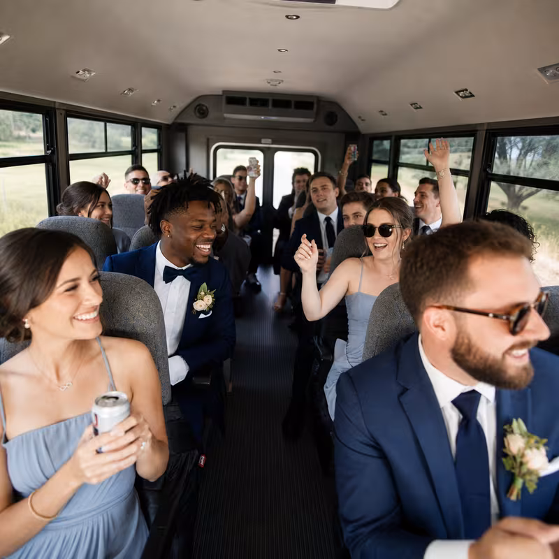 Group boarding a white charter bus for Wedding Transportation transportation in Toledo